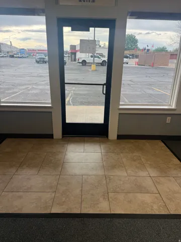 Commercial entry featuring a glass door and expansive windows