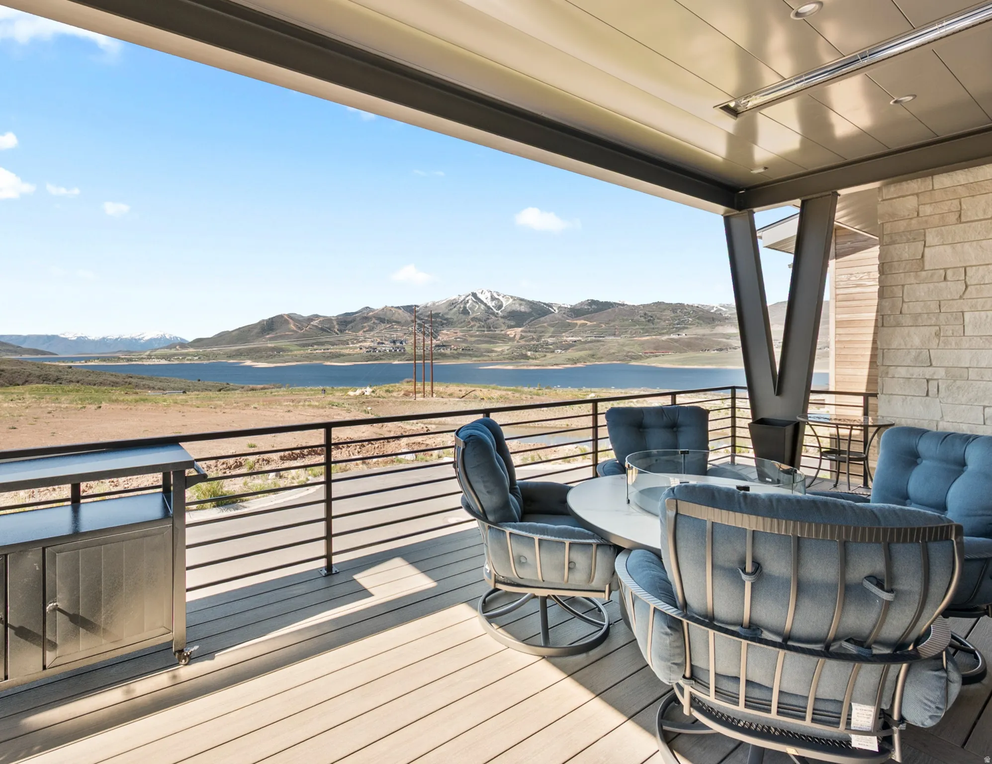 Spacious covered deck with composite decking and a black metal railing