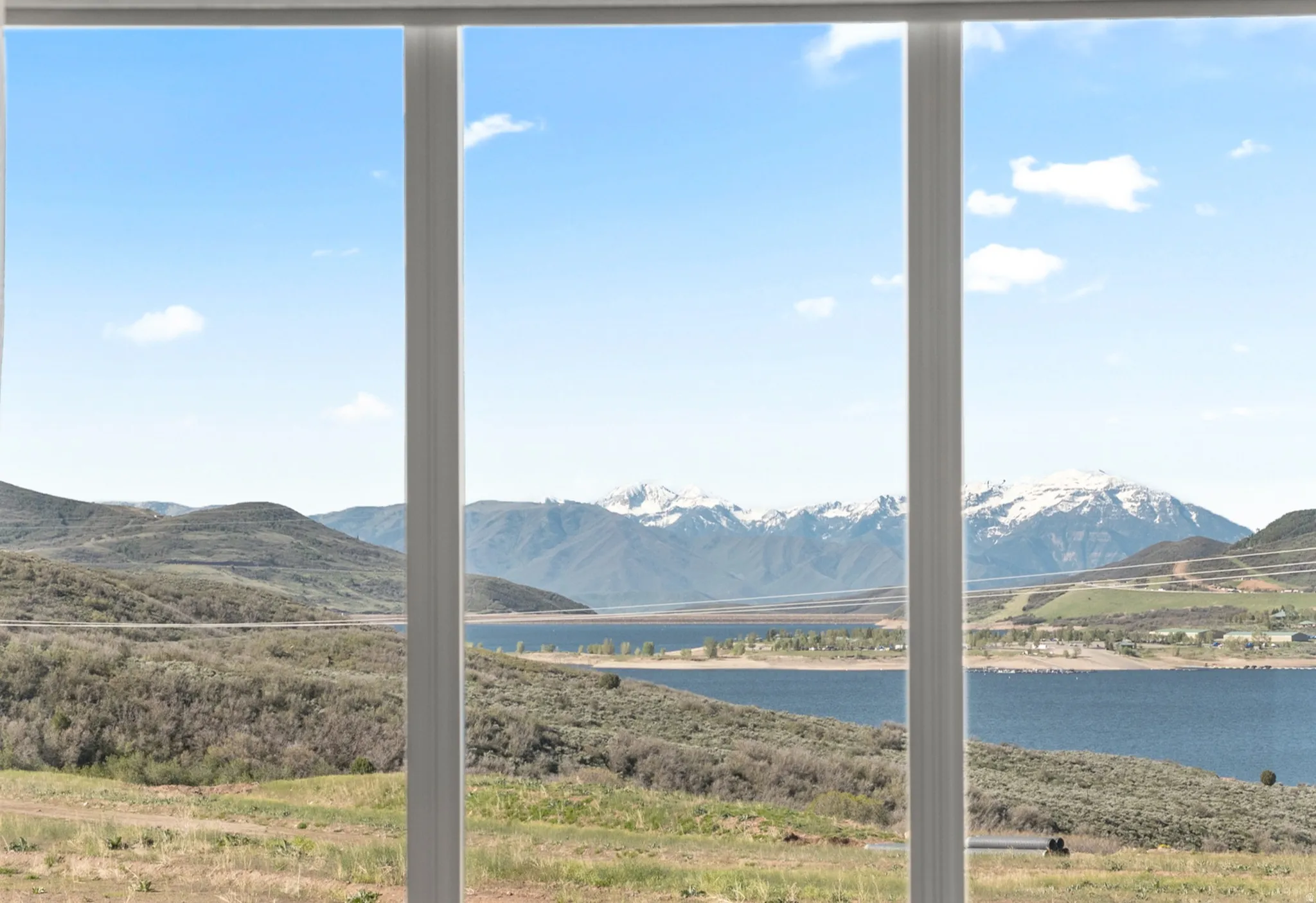 Expansive windows framing a mountain and lake landscape