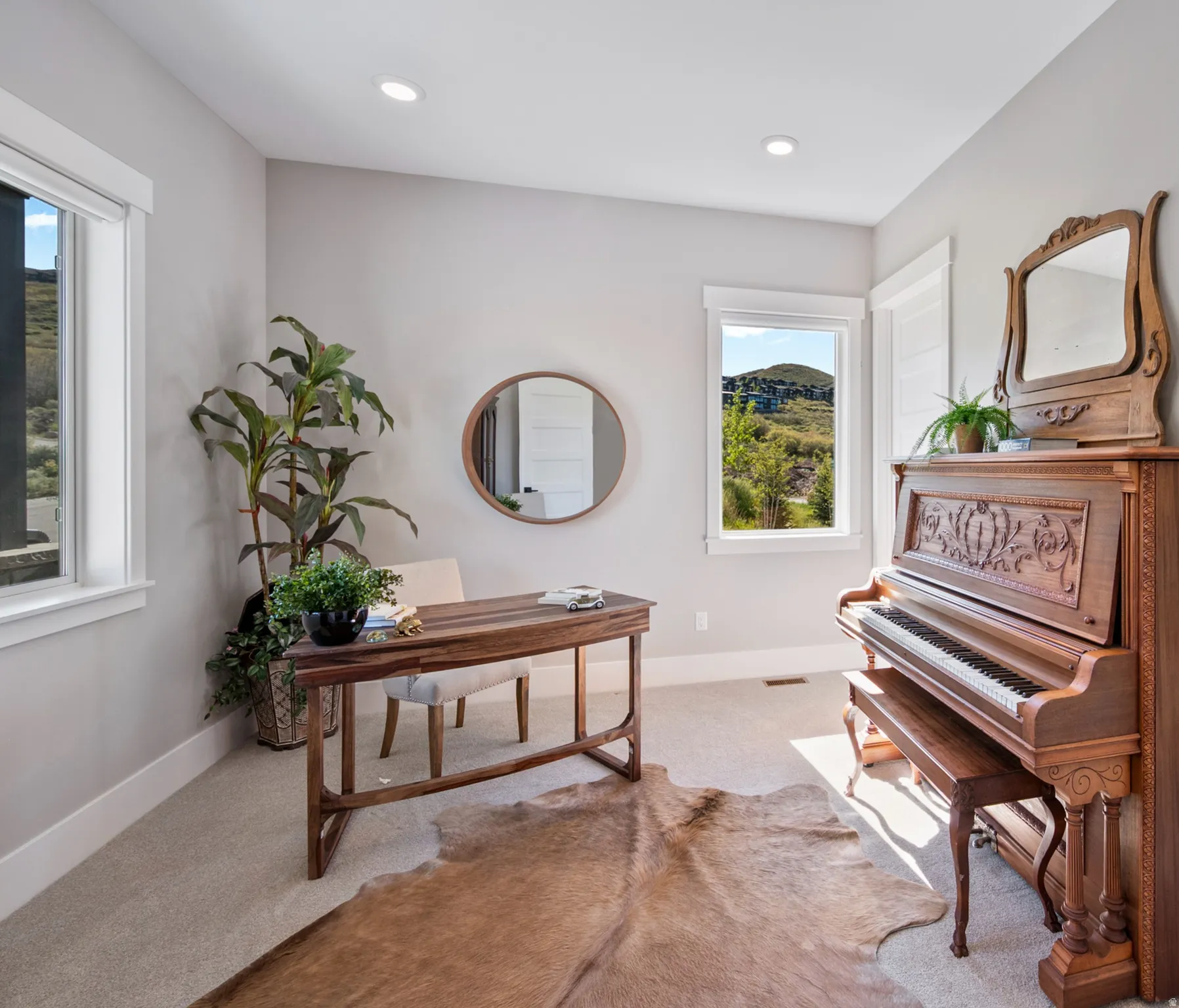 Light-filled room featuring recessed lighting, a neutral color palette, and two windows with white trim