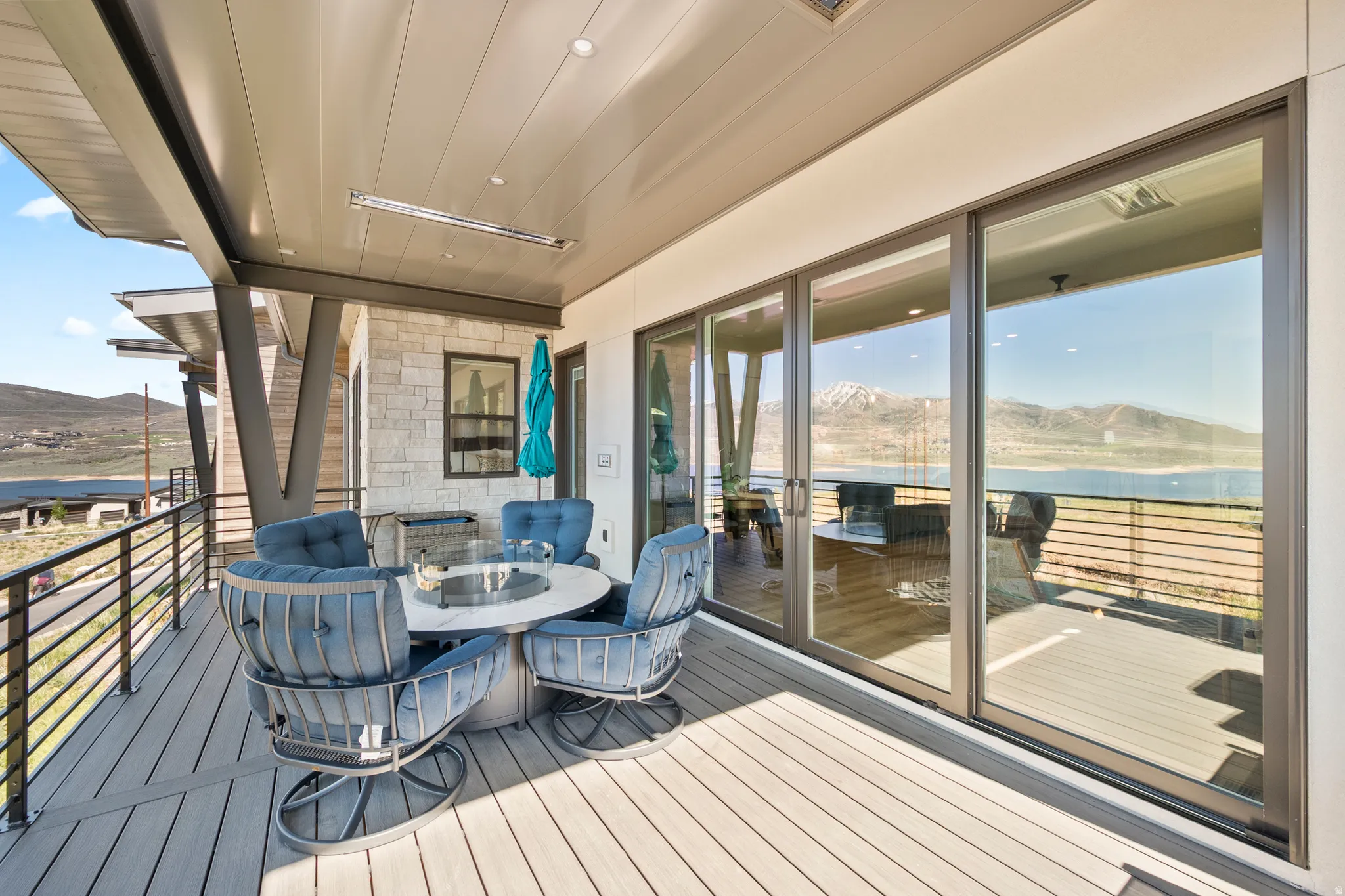 Spacious outdoor deck featuring composite decking, a metal railing system, and a built-in overhead heater
