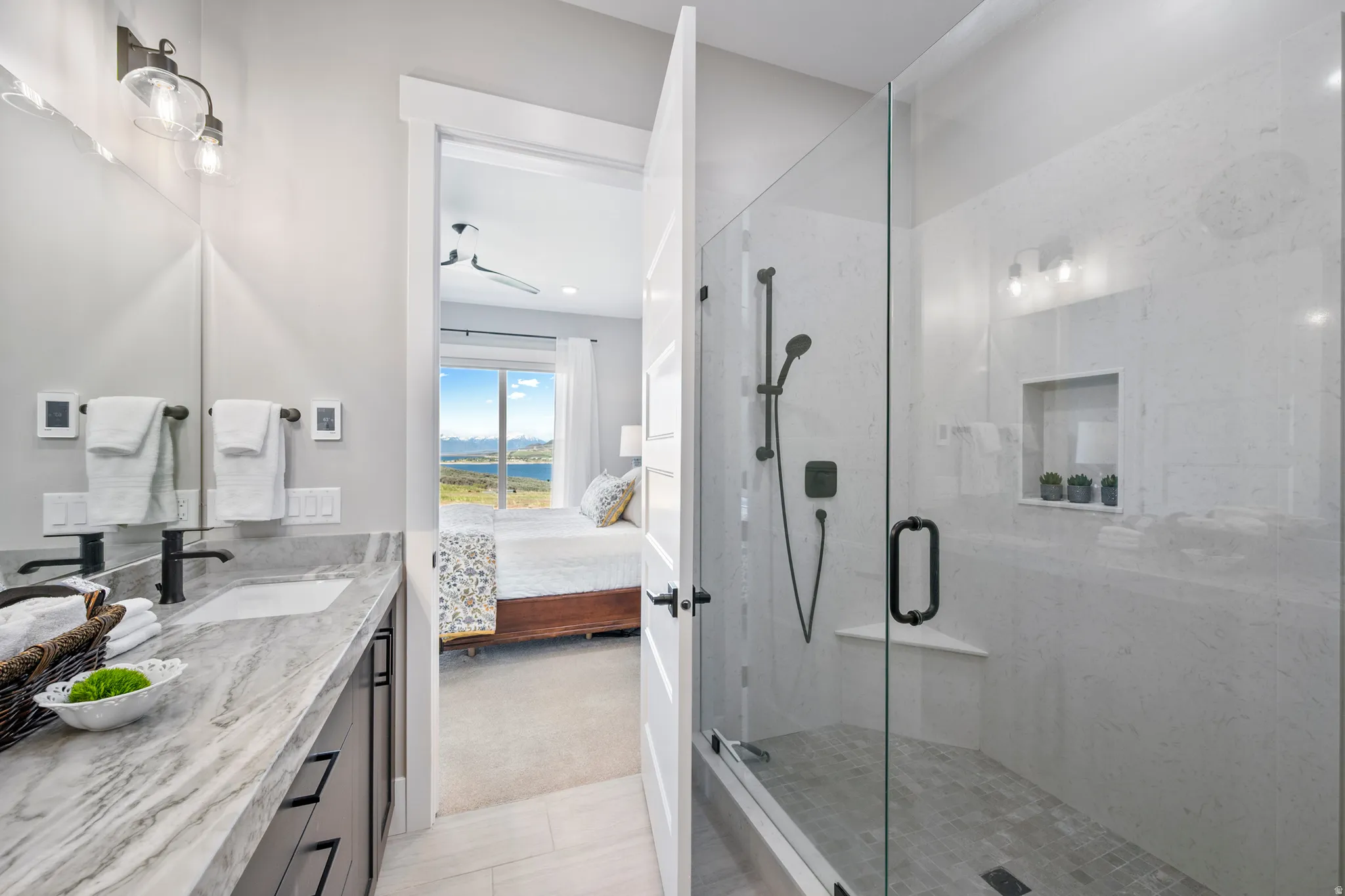 Bathroom featuring a dual vanity with quartzite countertop, undermount sinks, and matte black fixtures