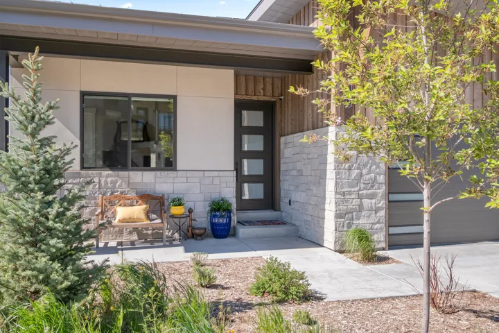 Modern exterior featuring stacked stone, vertical wood siding, and smooth paneling