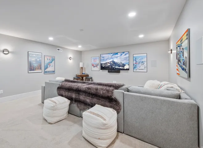 Spacious media room featuring recessed lighting, light-toned carpeting, and a built-in media speaker system