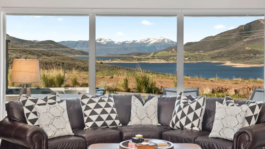 Expansive window wall with mountain and lake scenery