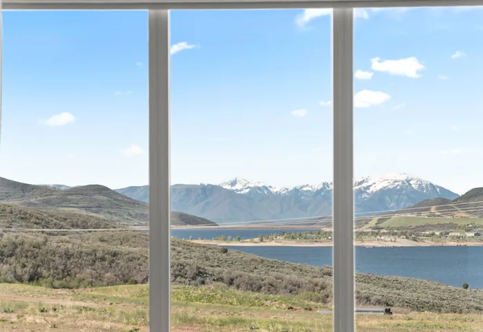 Expansive windows framing a mountain and lake landscape