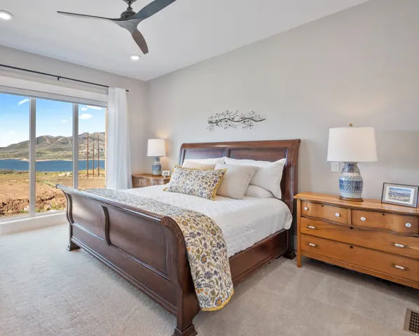 Full-height windows showcase a panoramic lake and mountain backdrop