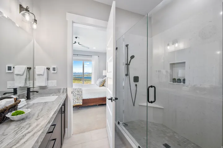 Bathroom featuring a dual vanity with quartzite countertop, undermount sinks, and matte black fixtures