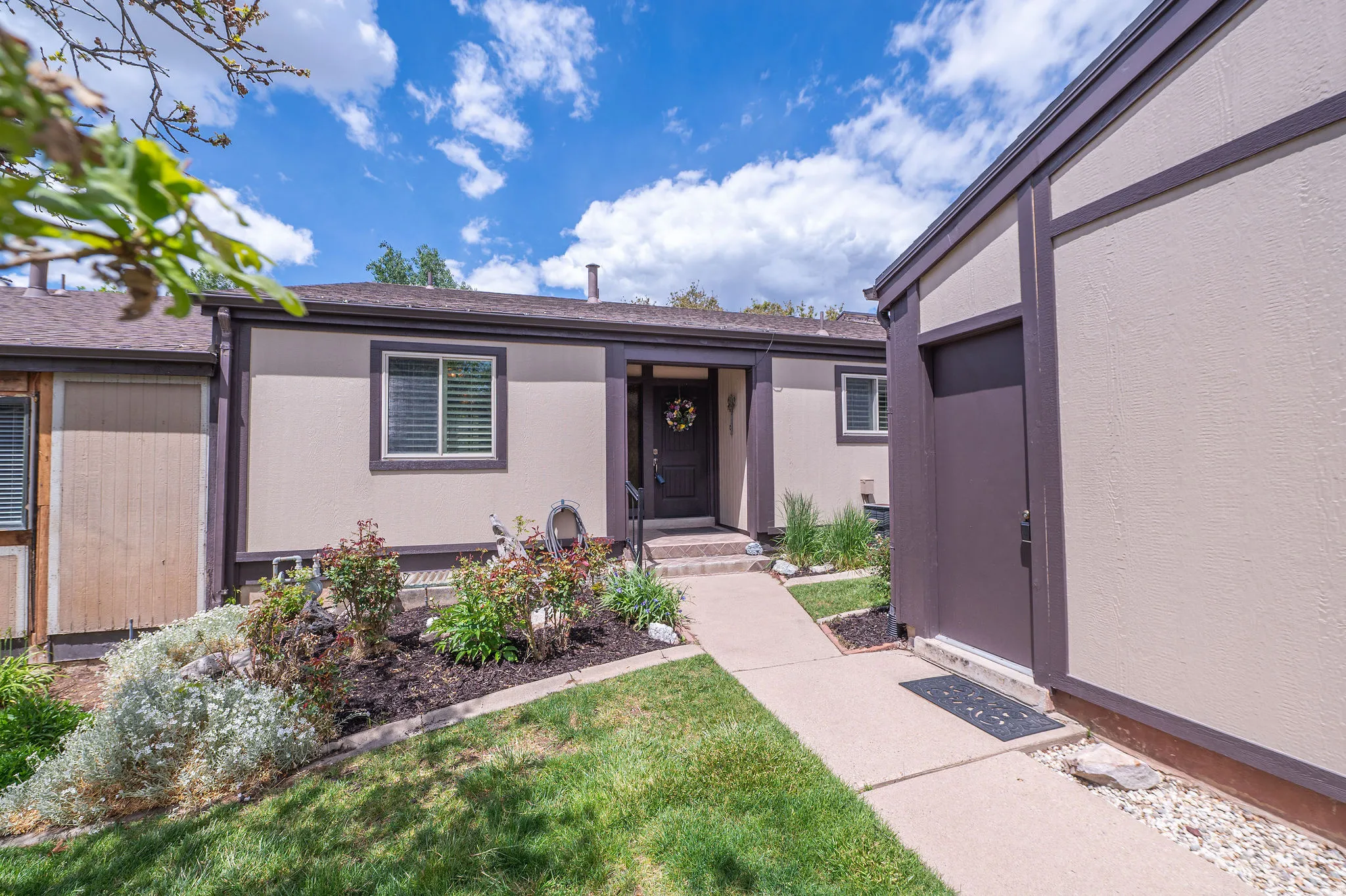 Neutral-toned exterior with dark trim accents and full landscaping.