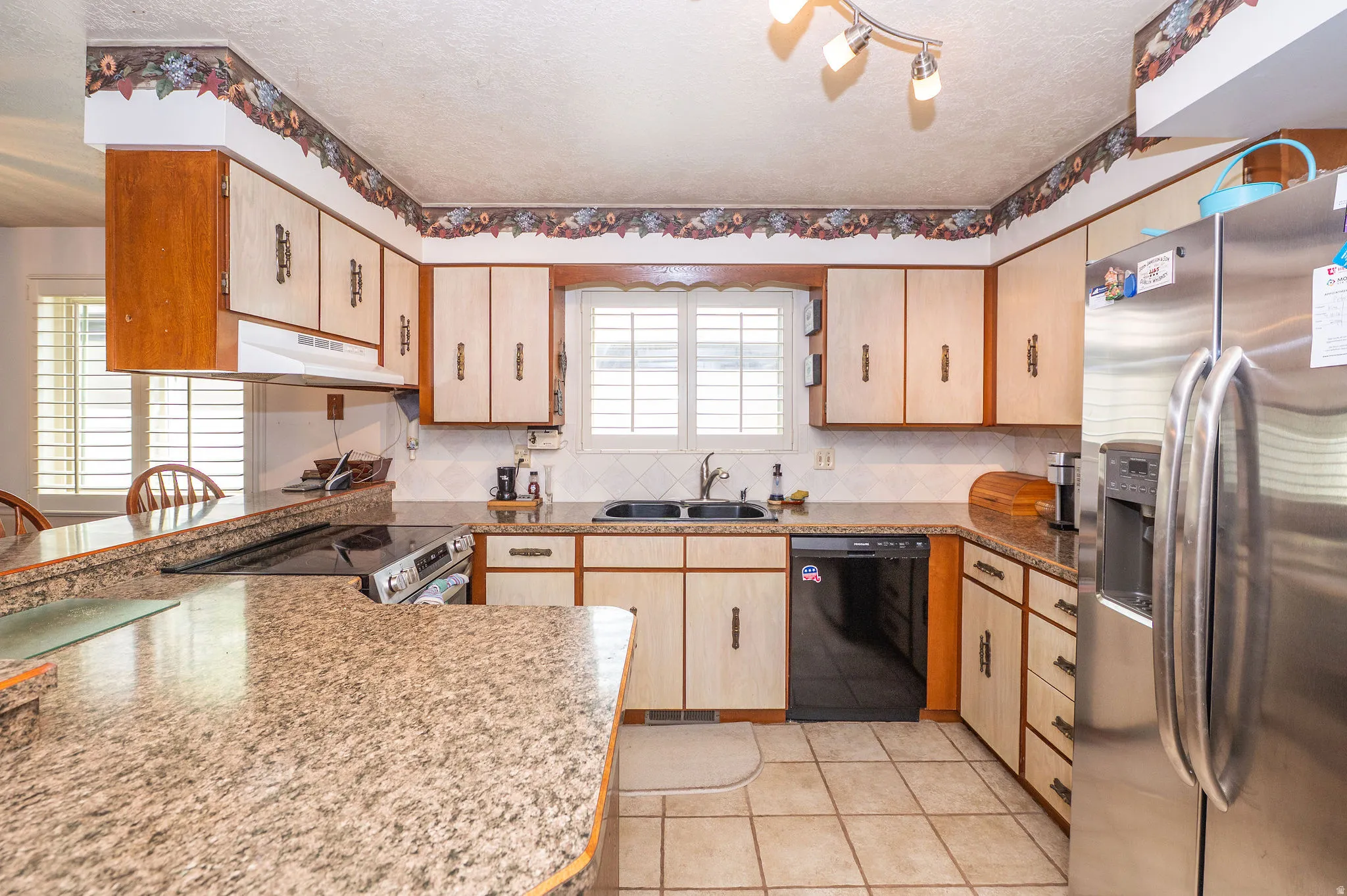 Kitchen featuring original cabinets, louvered shutters, and built-in dishwasher. Fridge not included.