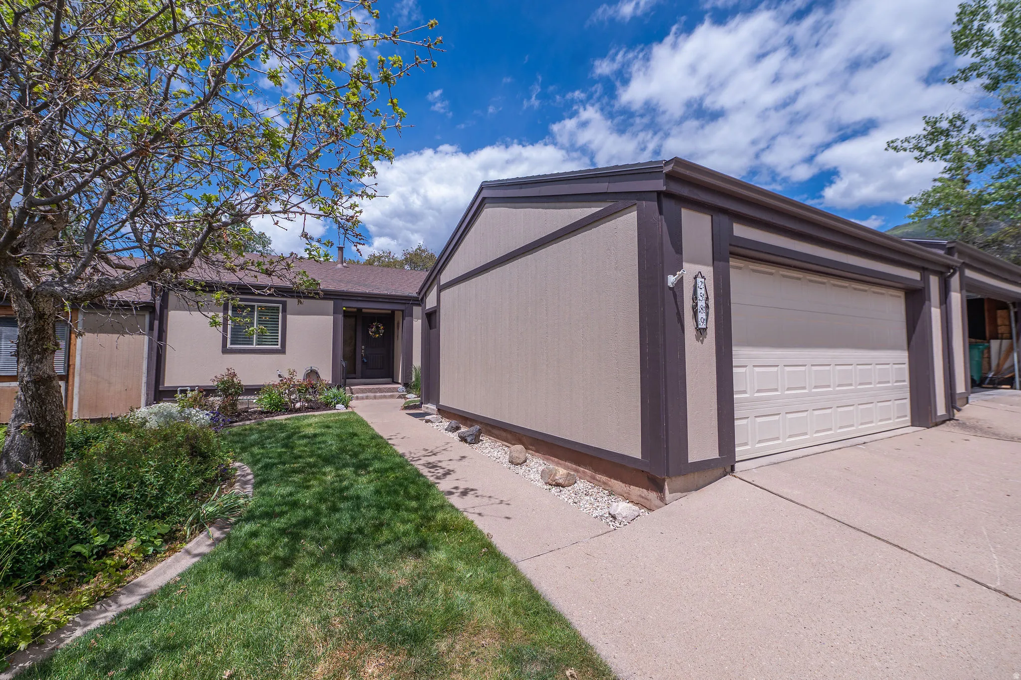 South facing frong exterior featuring a two-car garage, concrete driveway, and front walkway