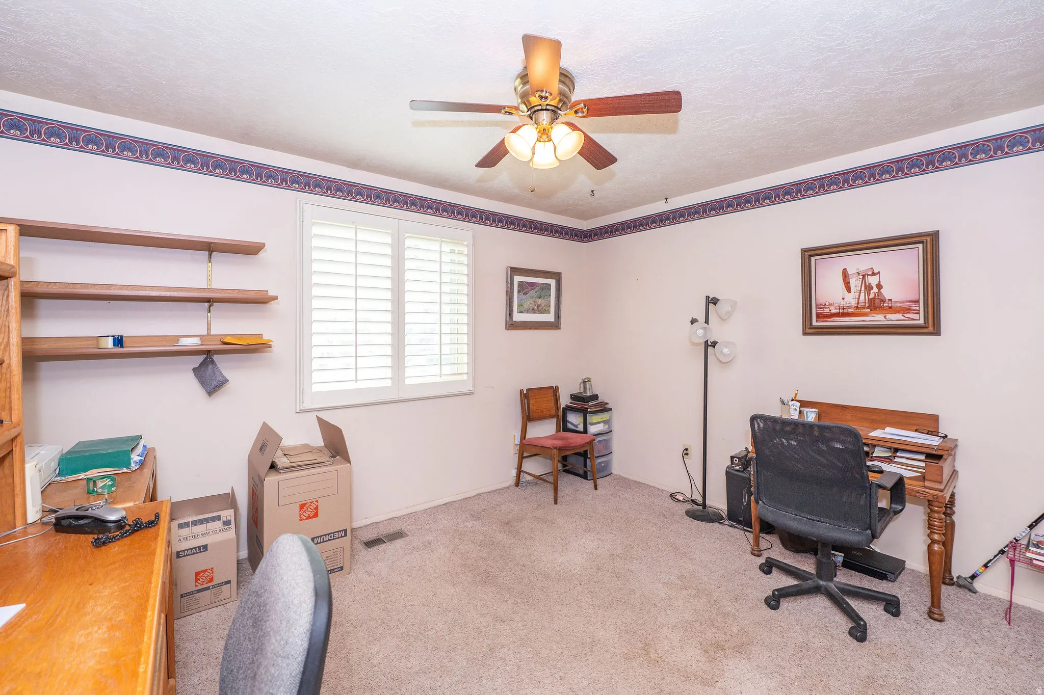 Interior room featuring light-toned carpet flooring, and a ceiling fan with integrated lighting