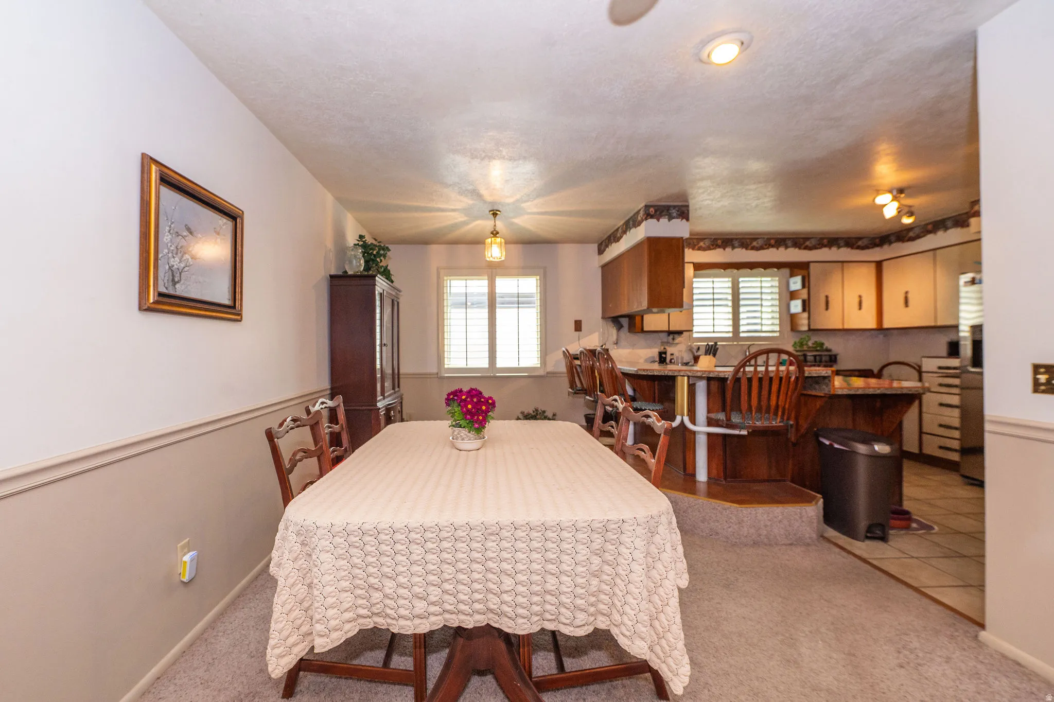 Dining area with carpet flooring and chair rail molding