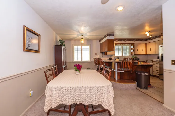 Dining area with carpet flooring and chair rail molding