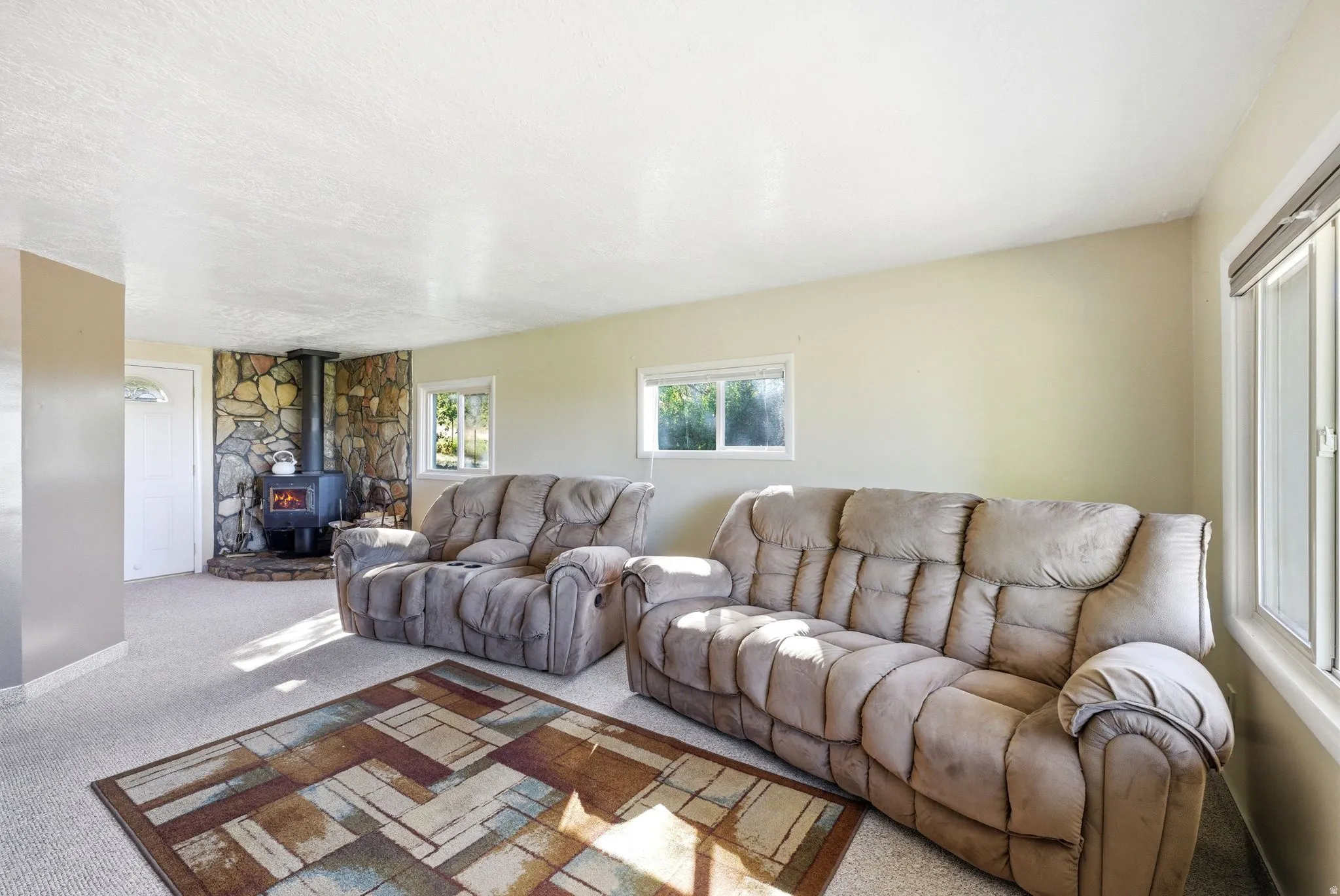 Living area featuring a freestanding wood-burning stove with a natural stone surround and hearth