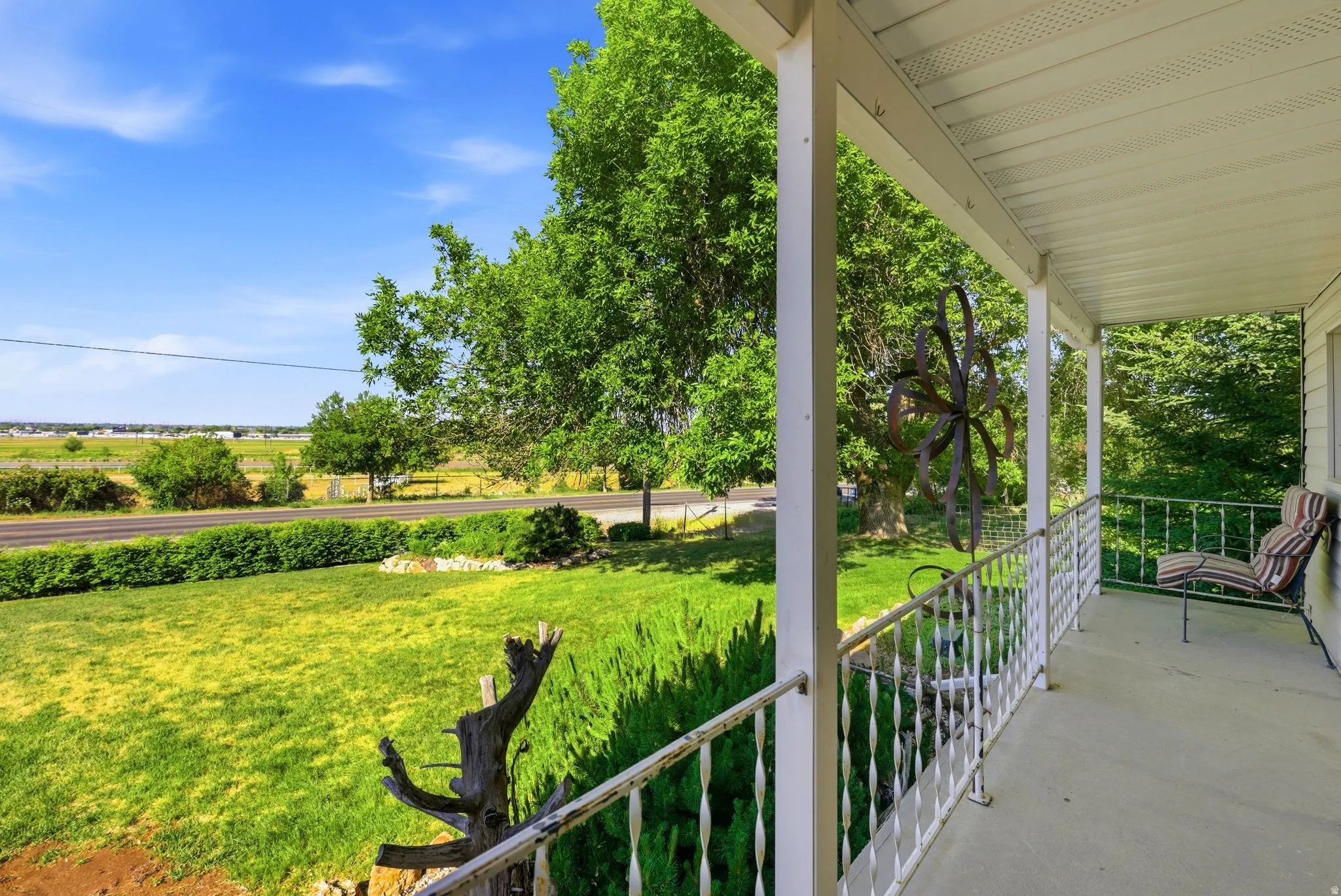Covered front porch with white railings and columns