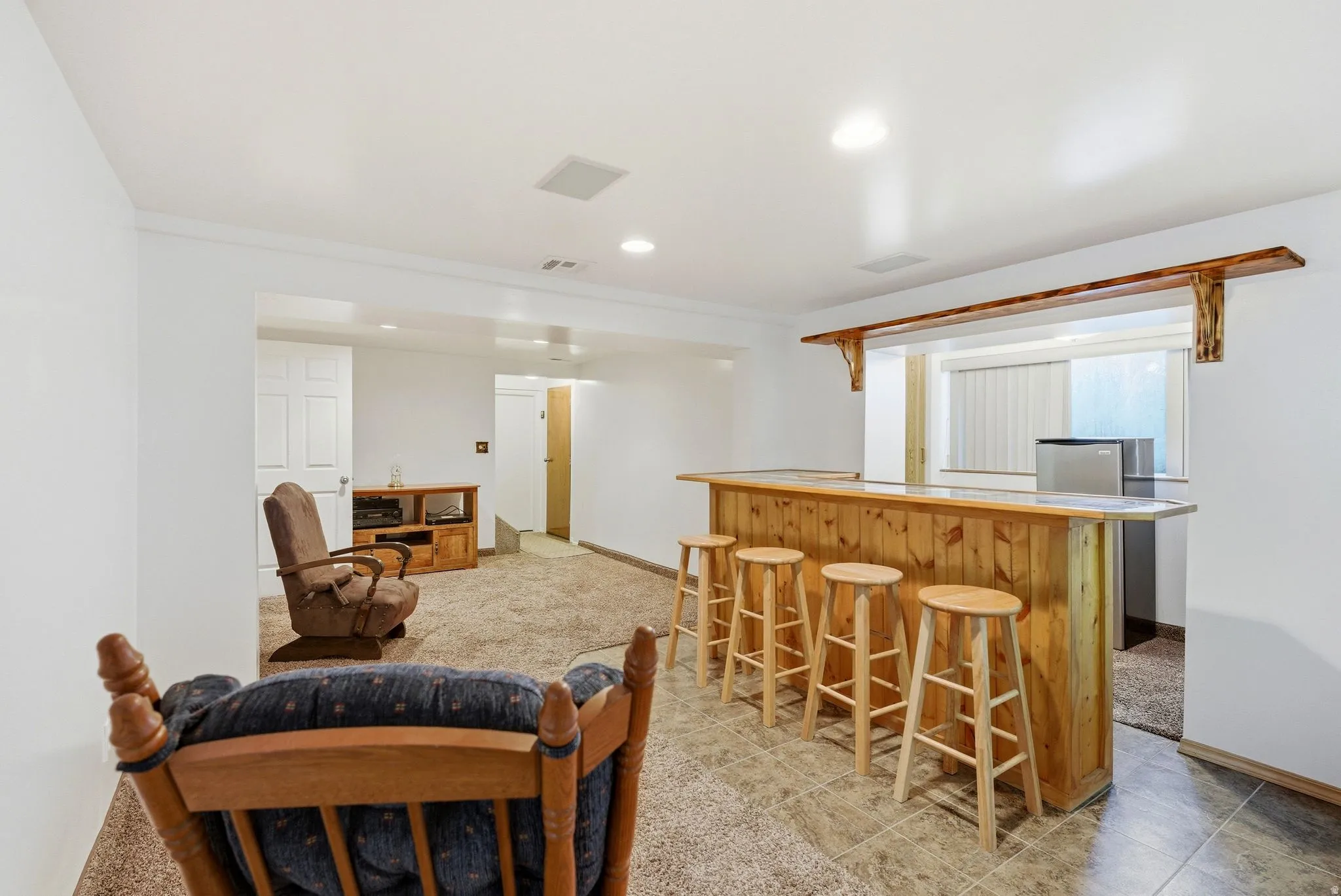 Finished basement featuring a custom wood-paneled bar with integrated seating