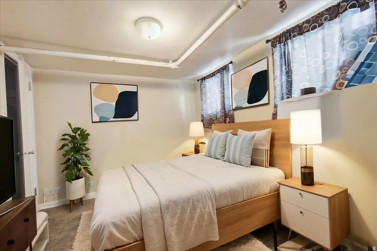 Bedroom featuring light-toned walls and wood-finish flooring