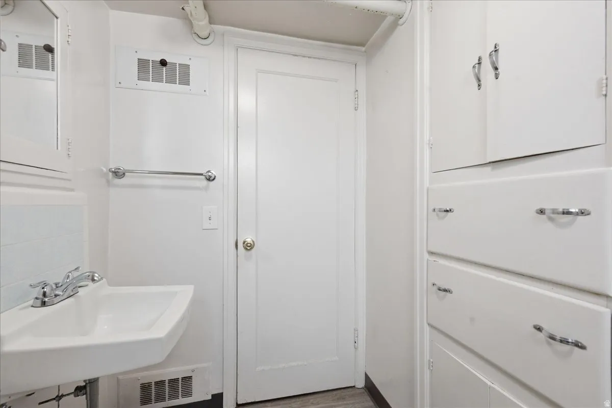 Wall-mounted sink with chrome faucet, complemented by a medicine cabinet with mirror