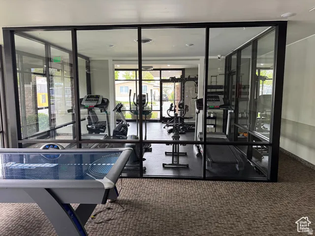 Dedicated fitness center featuring cardio equipment, strength training machines, and expansive glass partitions