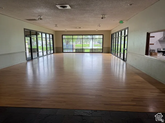 Spacious interior featuring wood-finish flooring, extensive floor-to-ceiling windows, and recessed lighting
