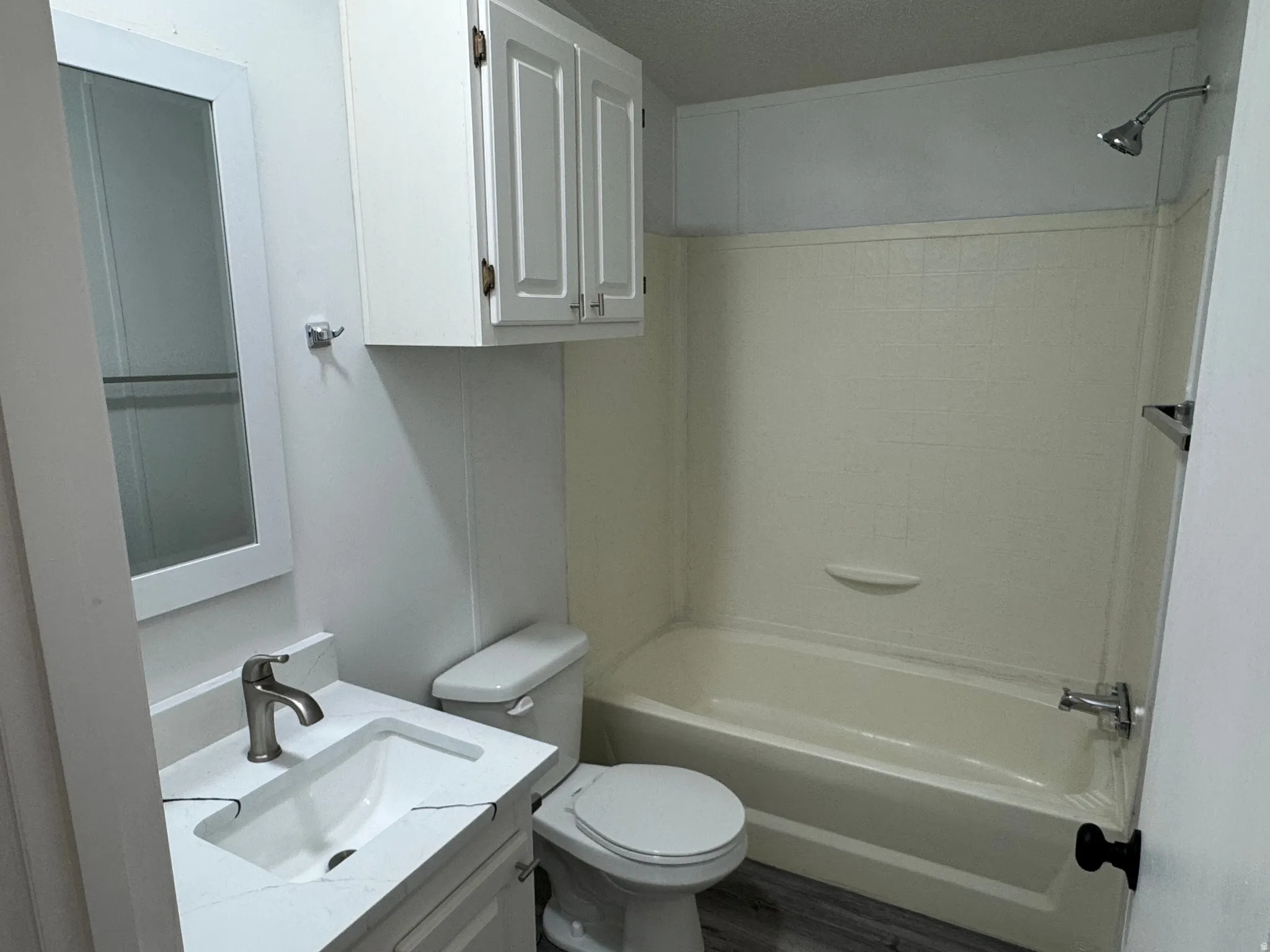 Bathroom featuring a single vanity with an integrated sink, brushed nickel faucet, and a large wall-mounted mirrored medicine cabinet