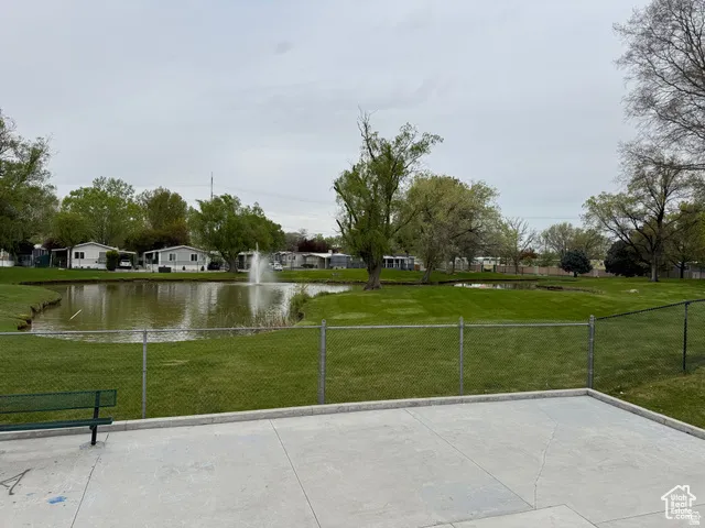 Expansive concrete patio overlooking a serene pond with a central fountain