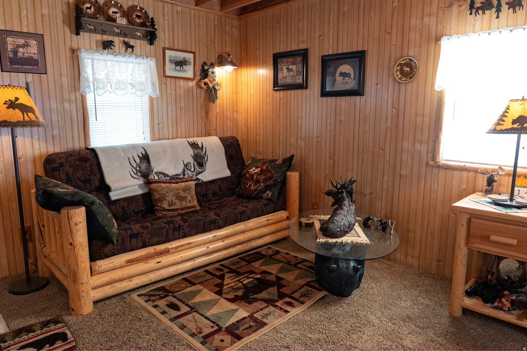 Wood-paneled room featuring neutral-toned carpeting, a window with horizontal blinds, and a built-in wooden shelf