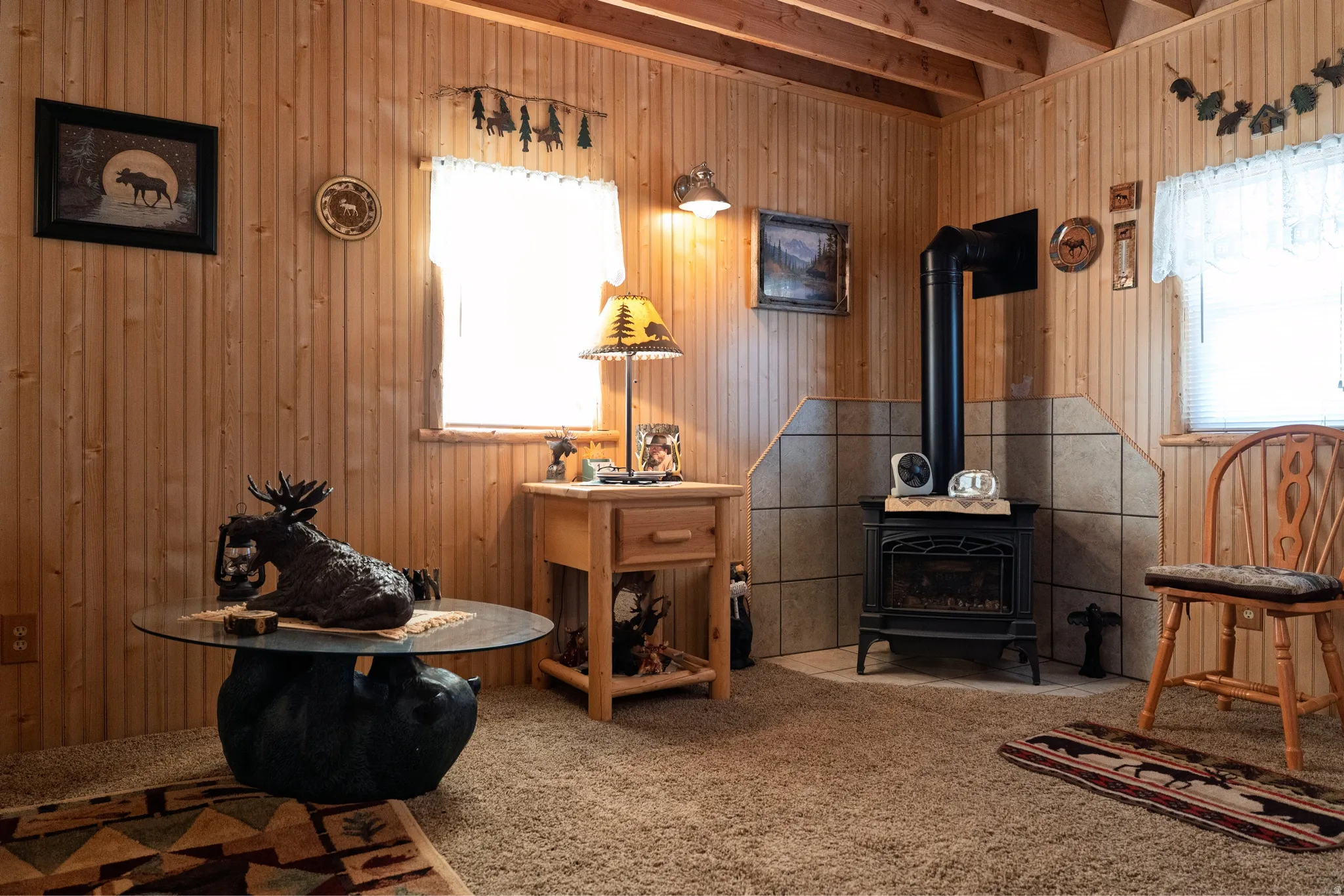 Wood-paneled room featuring a black cast-iron stove with a tiled surround