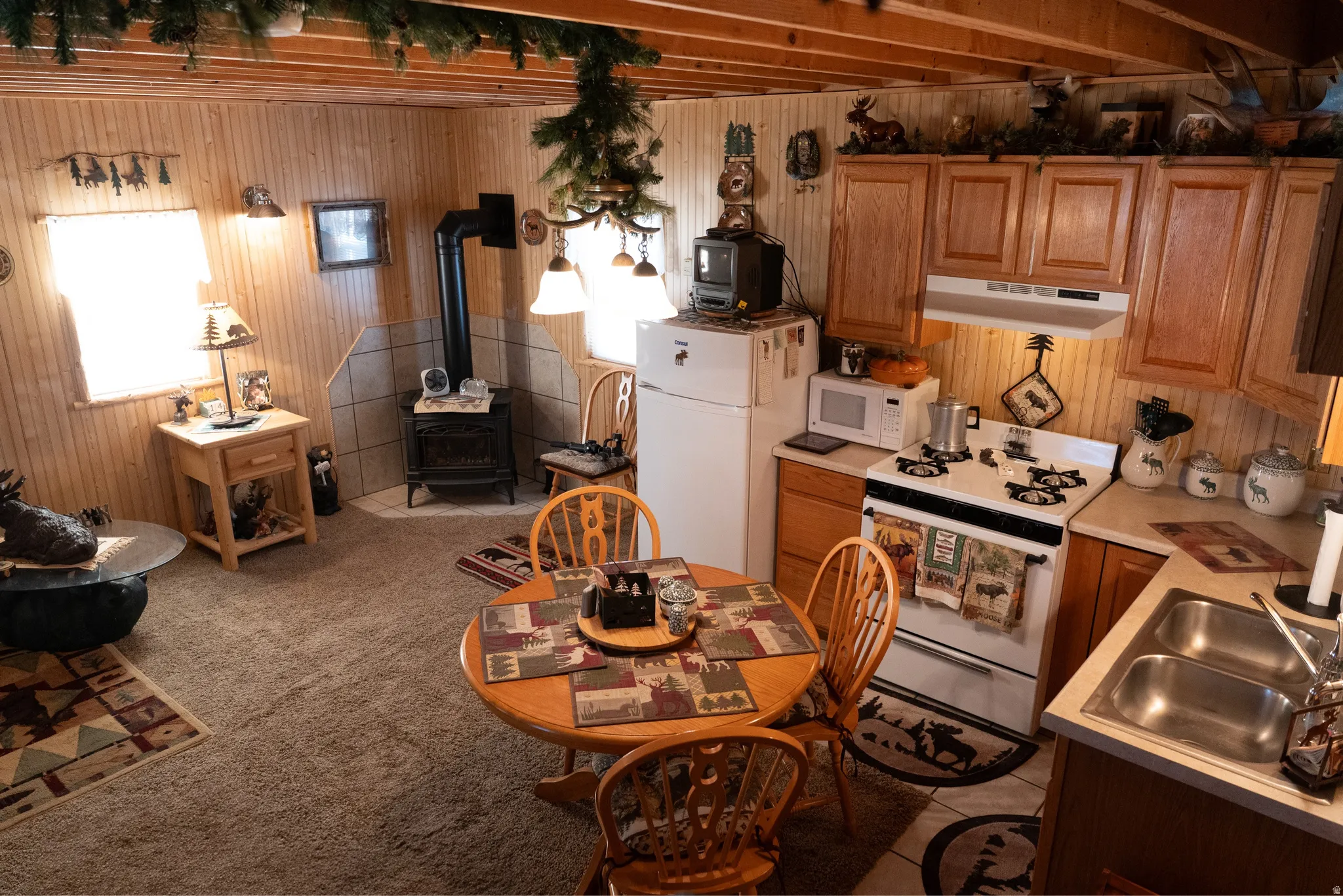 Open-concept living space featuring wood-paneled walls and a wood-beamed ceiling