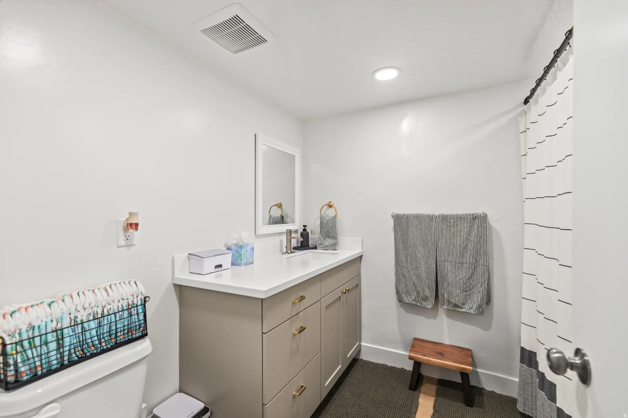 Bathroom featuring a neutral palette, recessed lighting, and a vanity with a white countertop