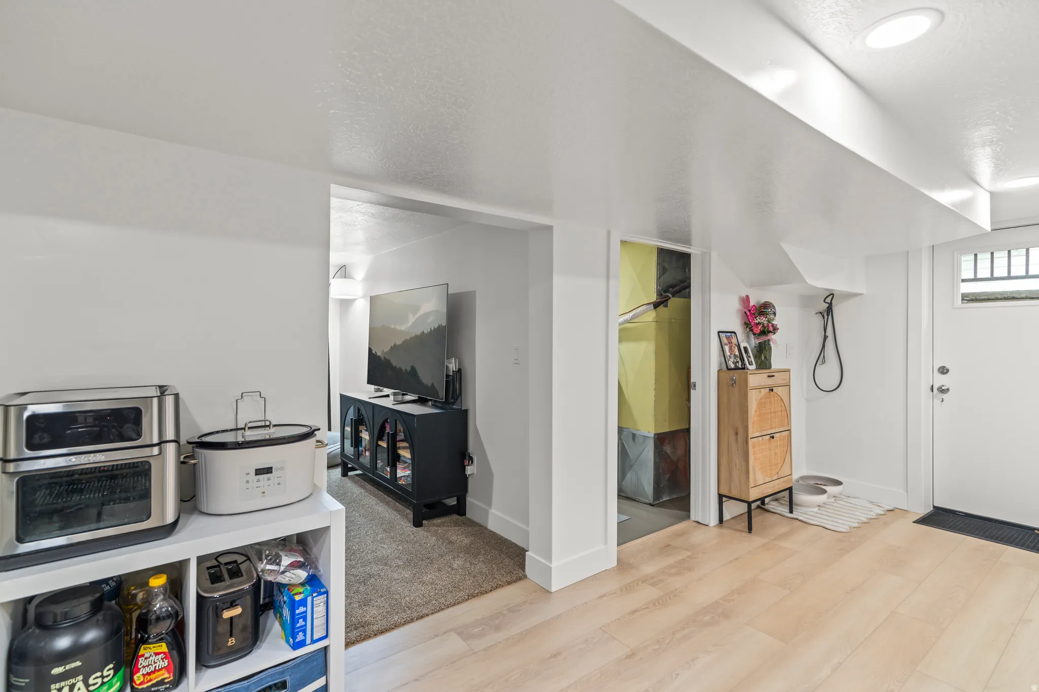 Light wood-finish flooring extending through the entry area
