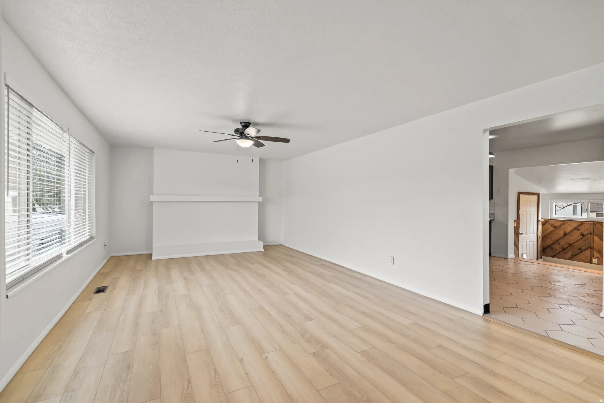 Bright living space featuring wood-finish flooring and white walls