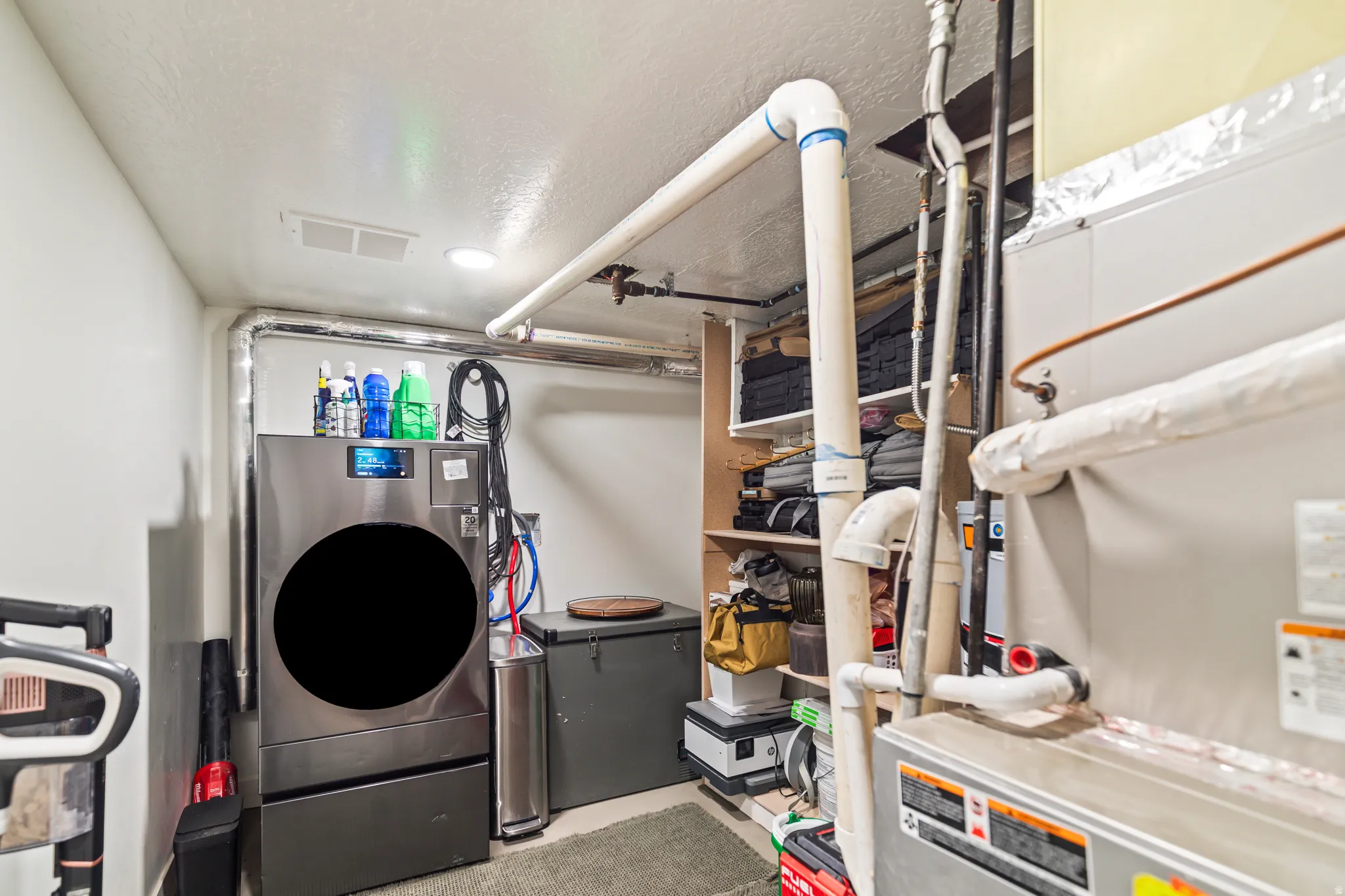 Utility room featuring a built-in shelving unit, exposed ductwork, and a recessed light fixture