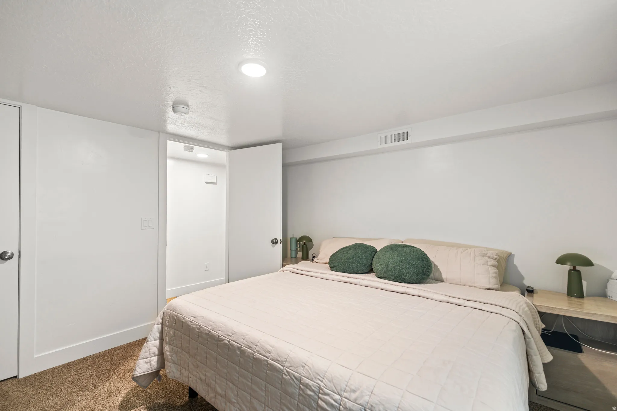 Bedroom featuring recessed lighting, a door with a chrome knob, and a doorway opening to an interior space