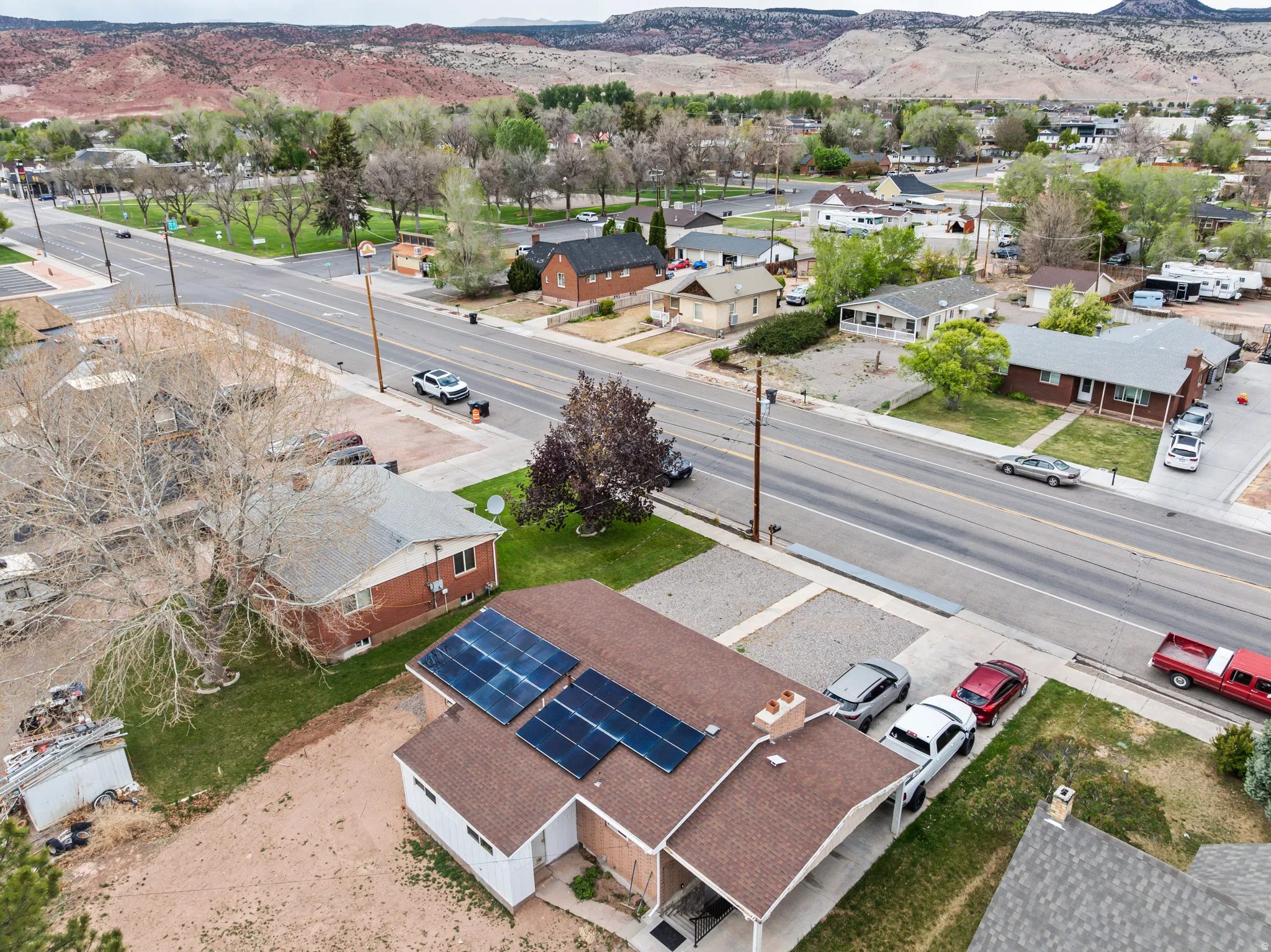 Property featuring solar panels, a covered entry, and a paved driveway