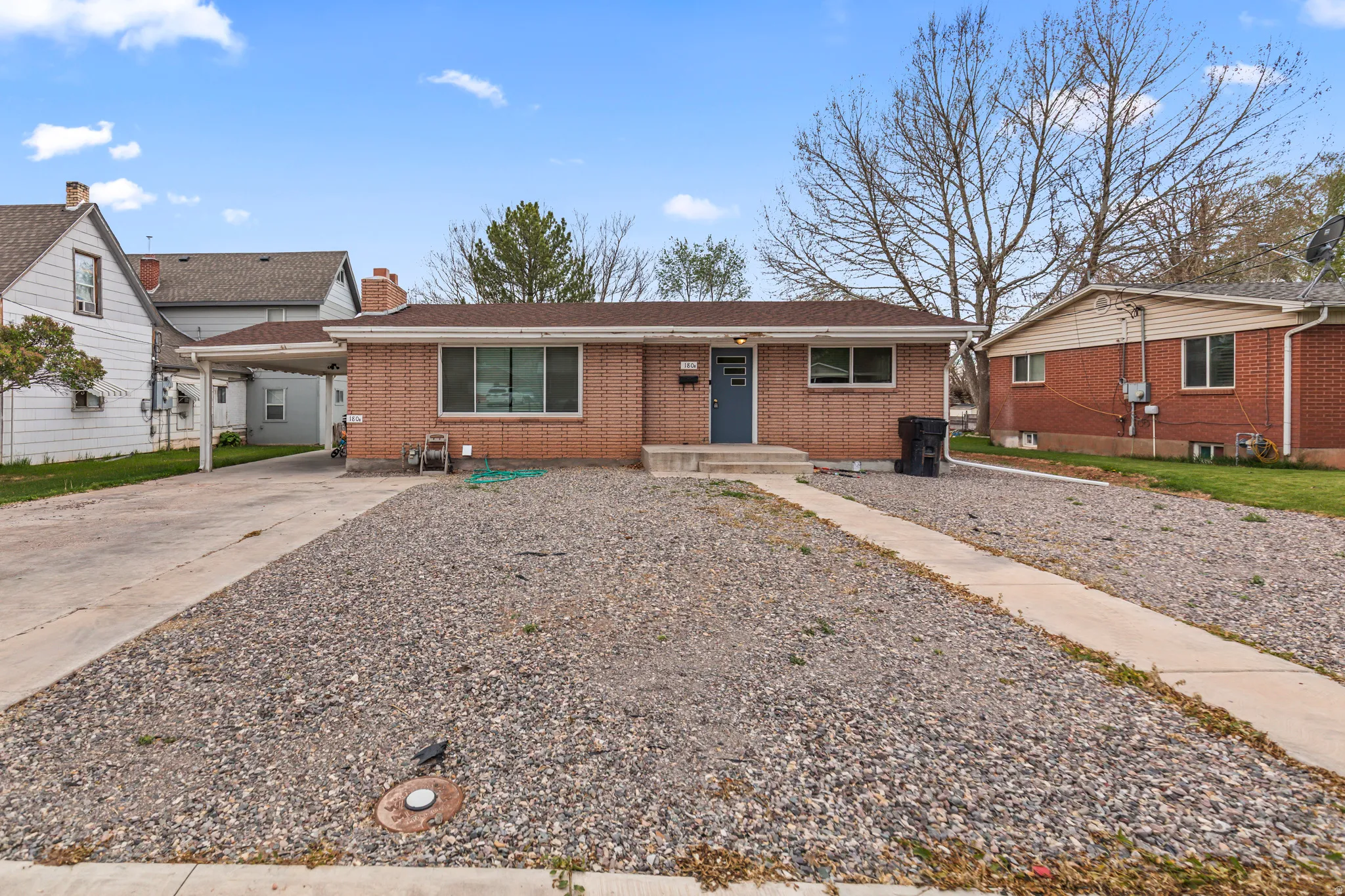 Brick-exterior residence featuring a carport and an entry walkway