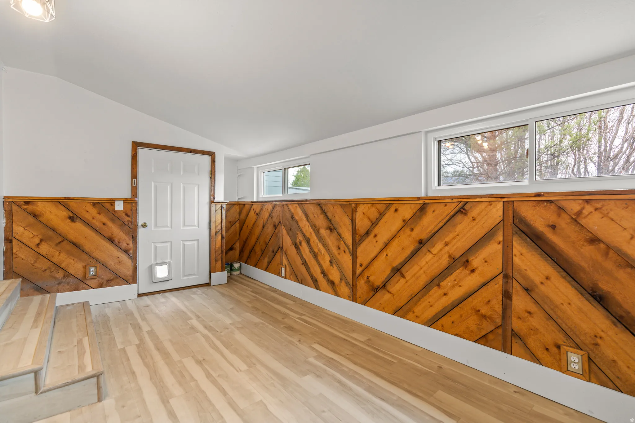 Wood-finish flooring throughout, complemented by chevron-patterned wood paneling