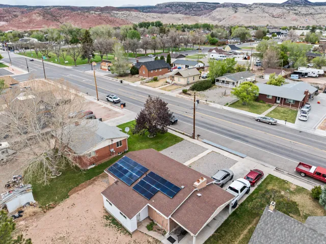 Property featuring solar panels, a covered entry, and a paved driveway