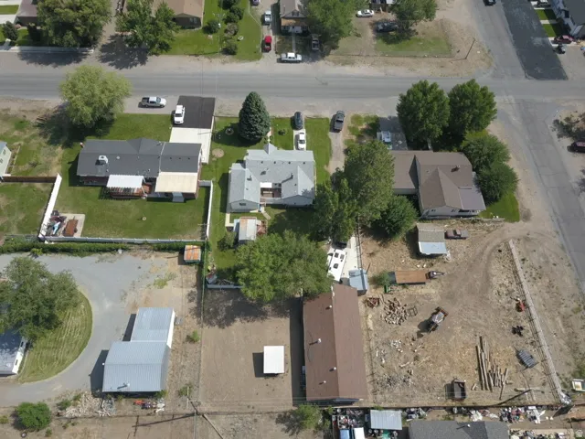 Expansive aerial perspective showcasing multiple residential properties and surrounding land