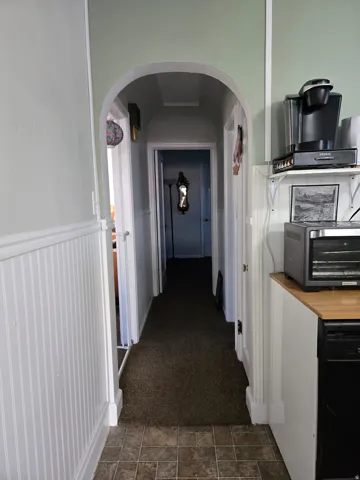 Archway entry to a hallway with carpeting