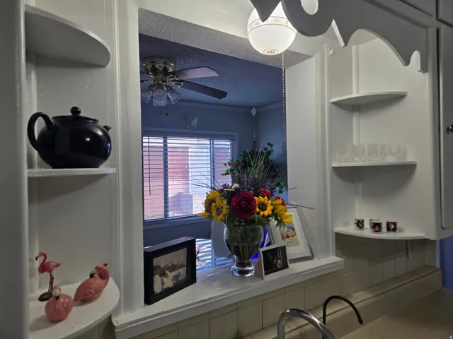 Pass-through window featuring a ceiling fan in the background
