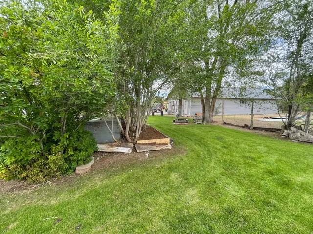 Expansive lawn bordered by mature trees and established landscaping