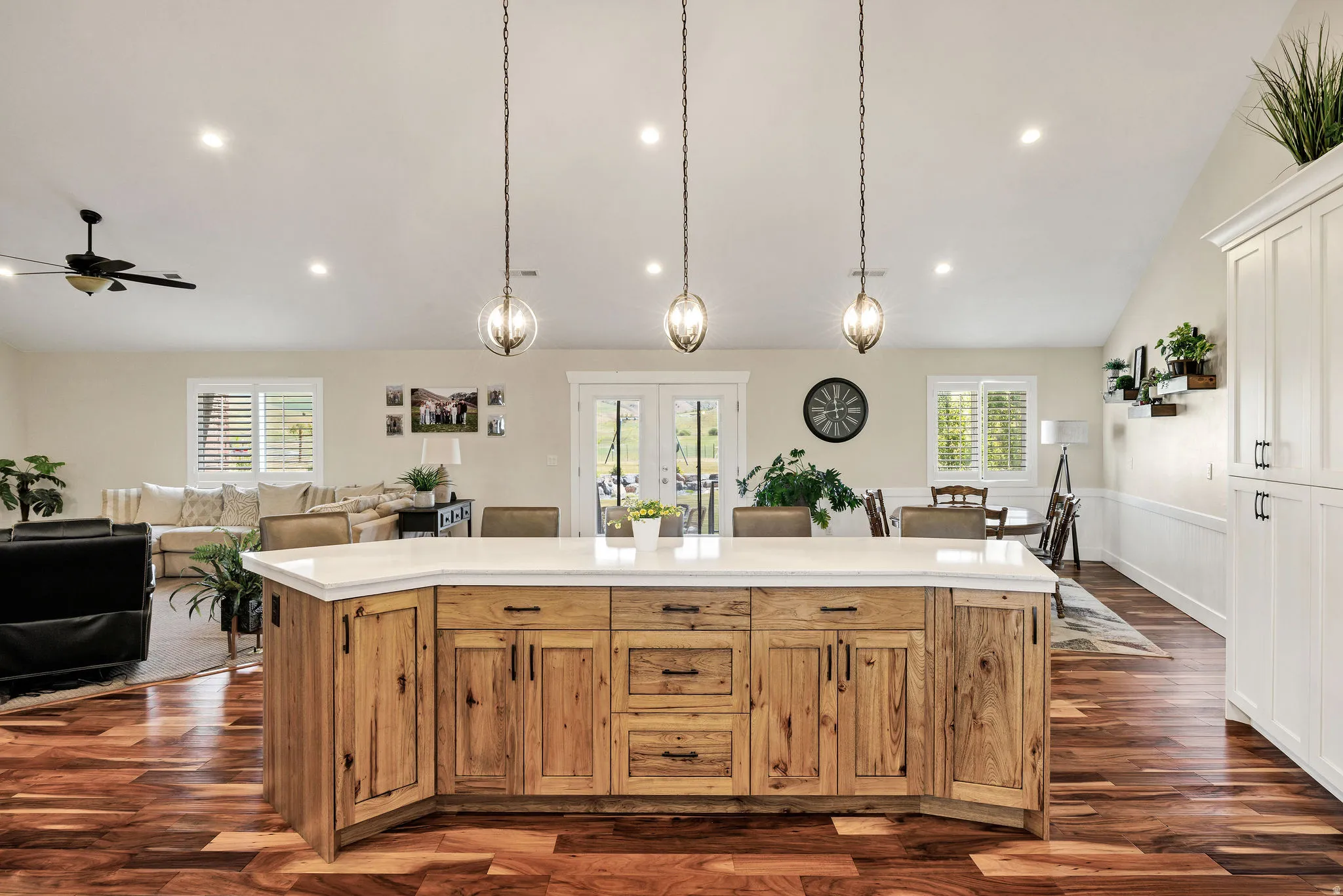 Spacious open concept living area featuring a large wood-finish kitchen island with a light-toned countertop, recessed lighting, and wood-finish flooring