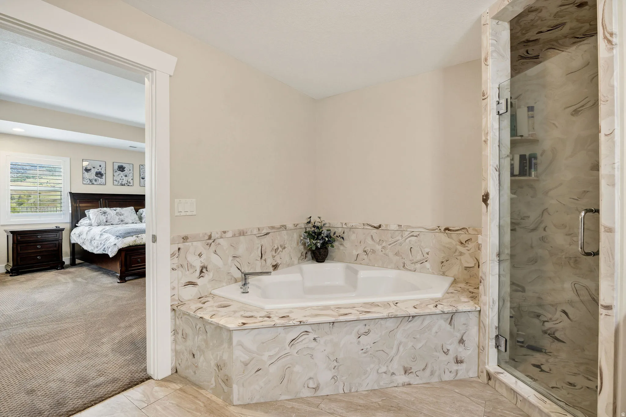 Corner soaking tub with stone-look surround and deck-mounted faucet