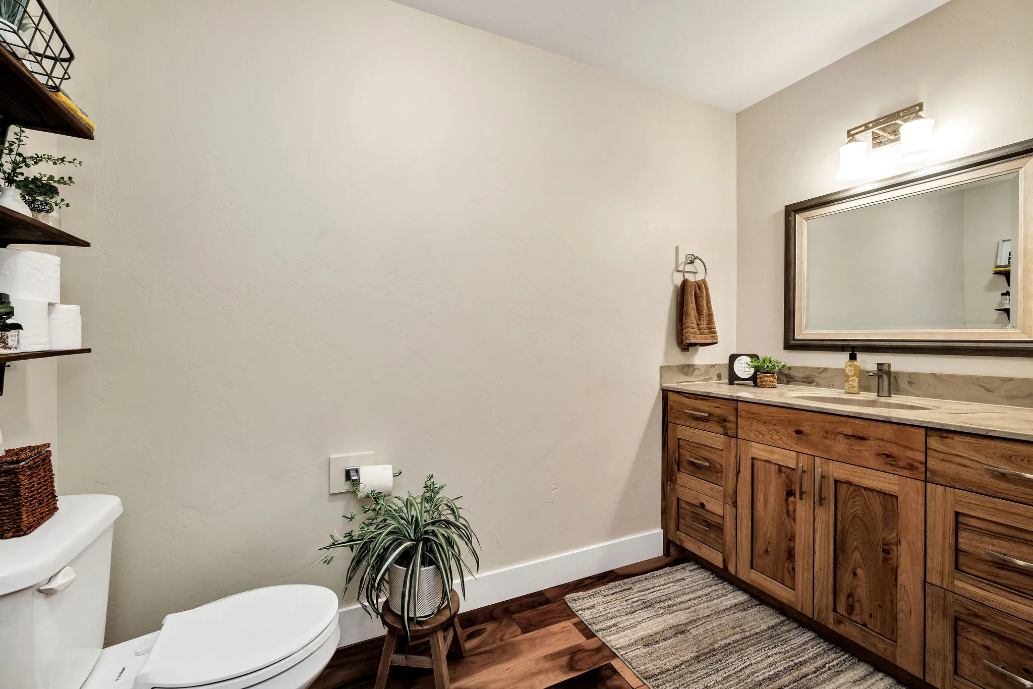 Bathroom featuring a vanity with a light-toned countertop, a rectangular mirror with a dark frame, and a two-light fixture