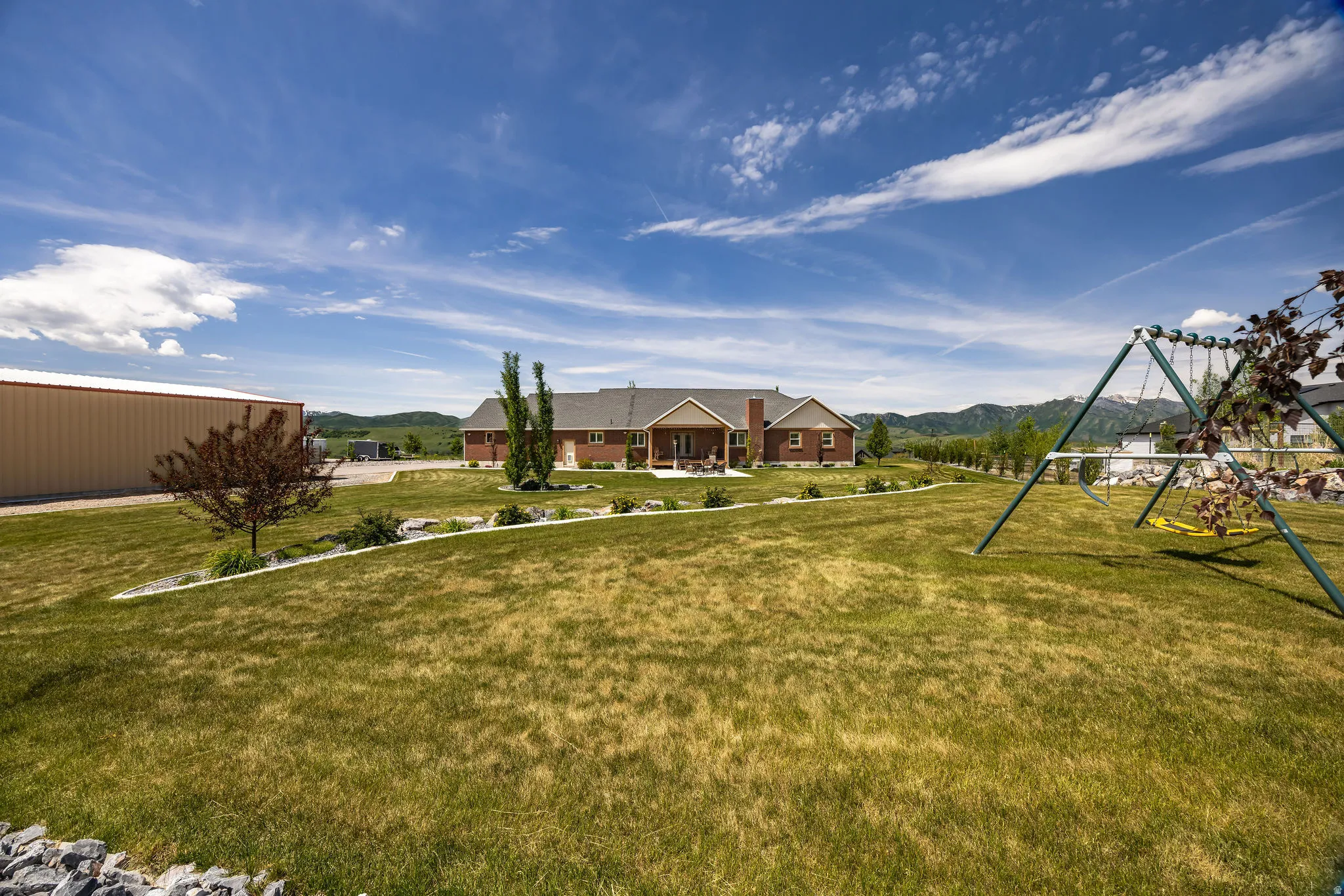 Expansive exterior showcasing a single-story residence with a brick facade and covered patio