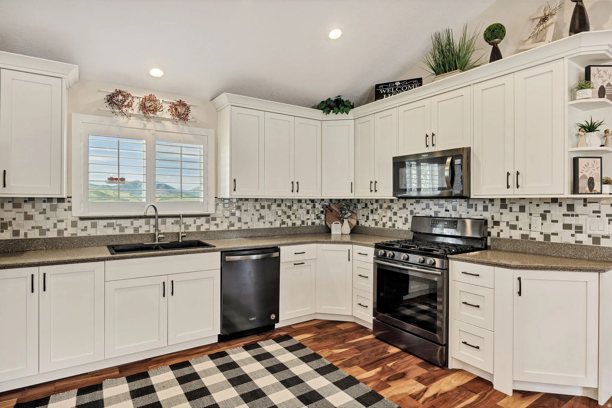 Kitchen featuring abundant white cabinetry, a black appliance suite, and a multi-tone tile backsplash