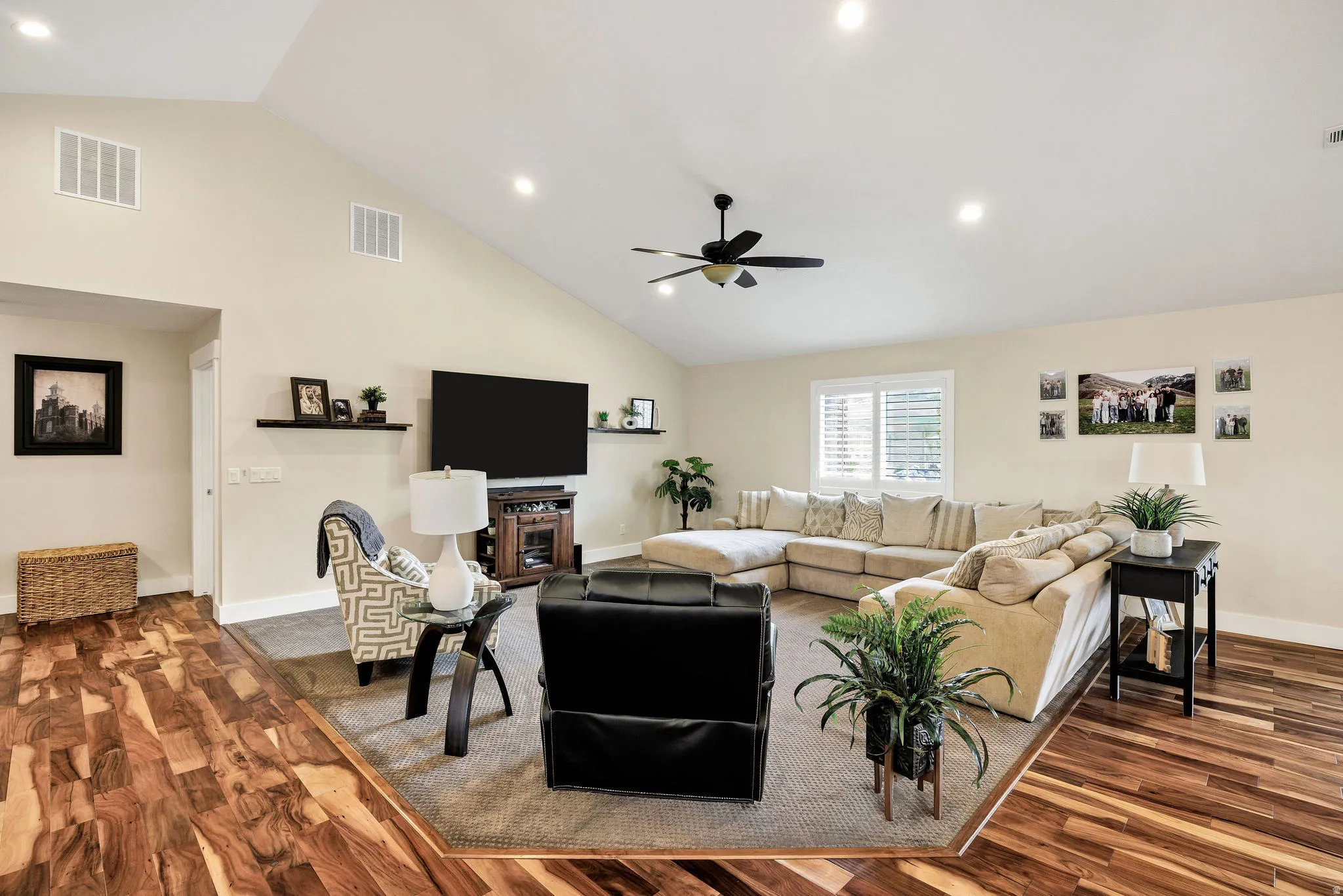 Expansive living area featuring vaulted ceilings, recessed lighting, and rich wood-finish flooring