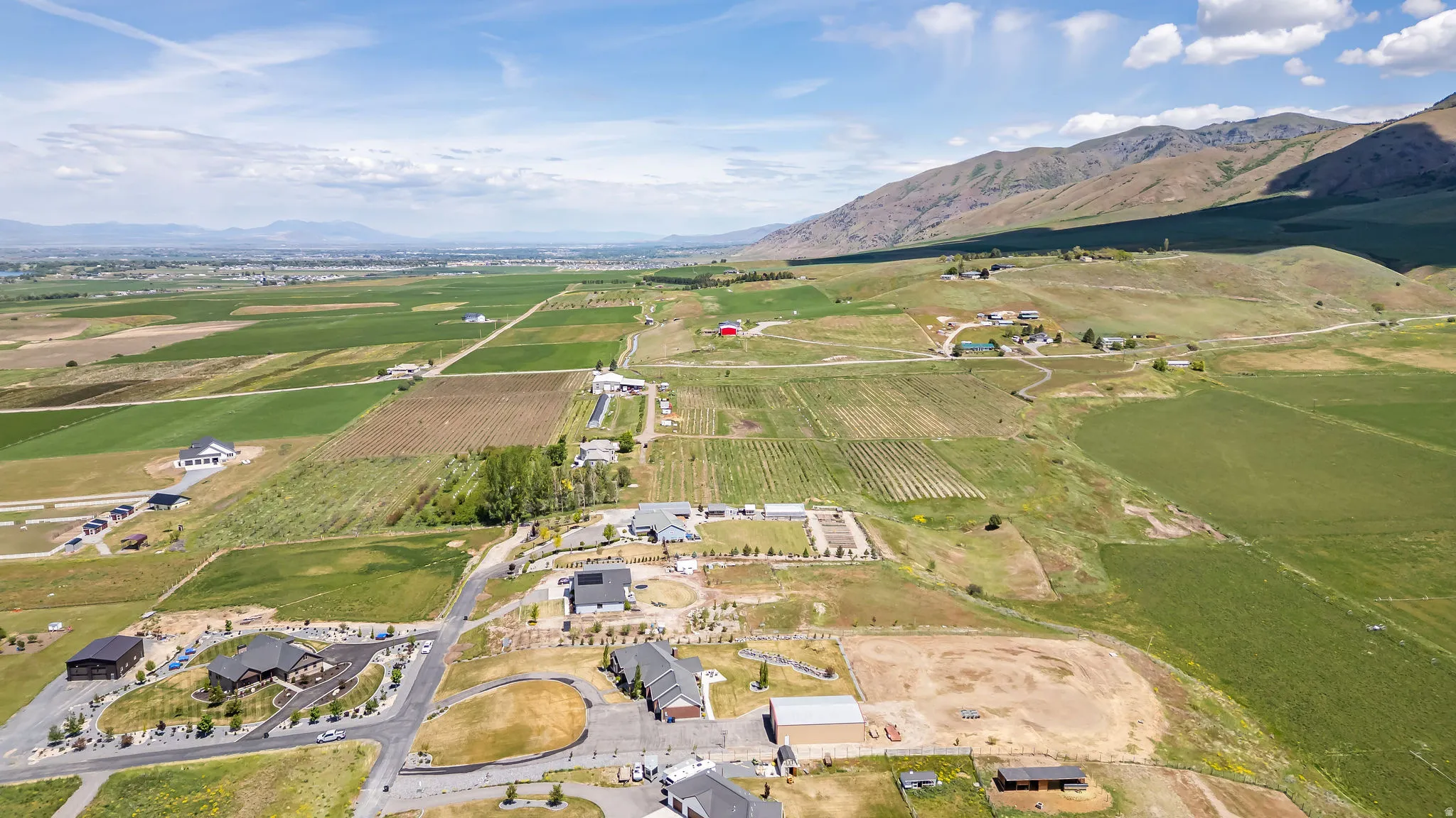 Expansive rural landscape featuring a mix of agricultural fields and residential properties